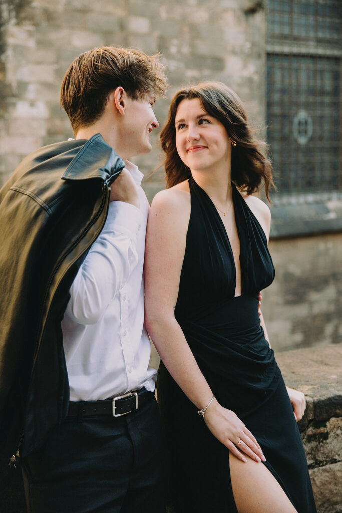 Para patrząca sobie w oczy na tle średniowiecznych murów w Barcelonie.