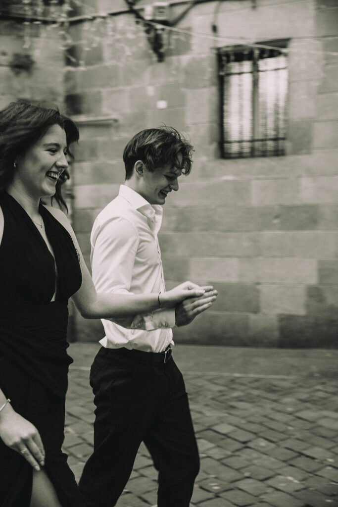 Biegnąca para podczas sesji w Dzielnicy Gotyckiej w Barcelonie.