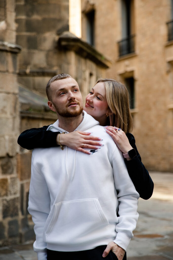 Szczęśliwa para przytulająca się po zaręczynach w Barcelonie – bliska sesja lifestylowa.