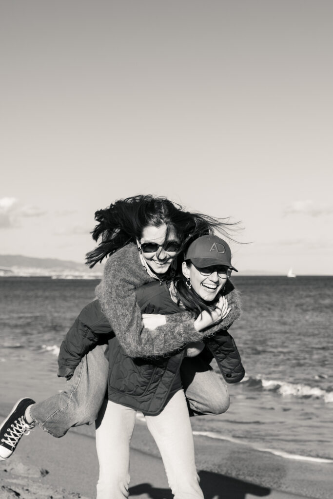 Dziewczyny śmiejące się na plaży w Barcelonie.