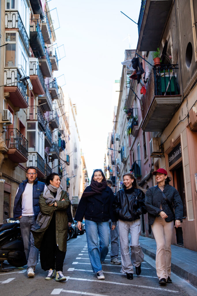 Rodzina biegnąca przez zabytkowe uliczki dzielnicy El Born w Barcelonie, sesja lifestylowa.
