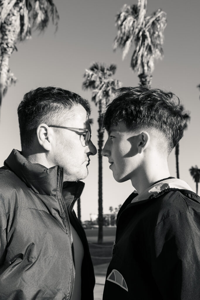 Syn z ojcem na tle palm w Barcelonie.